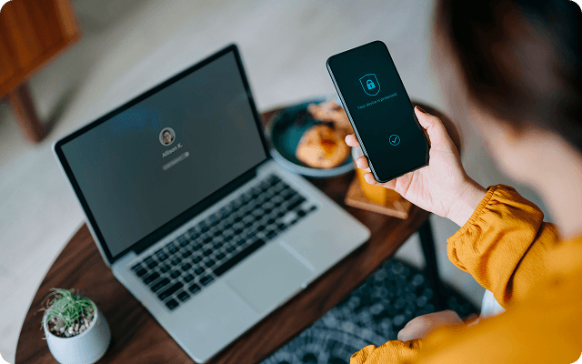 woman looking at her mobile and laptop