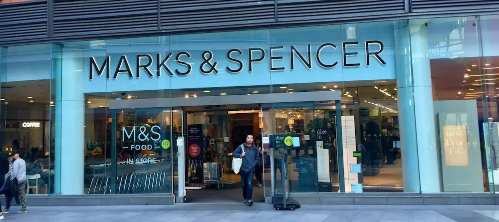 Shopper walking out of a Marks & Spencer store.