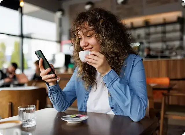 Person using smartphone at cafe.