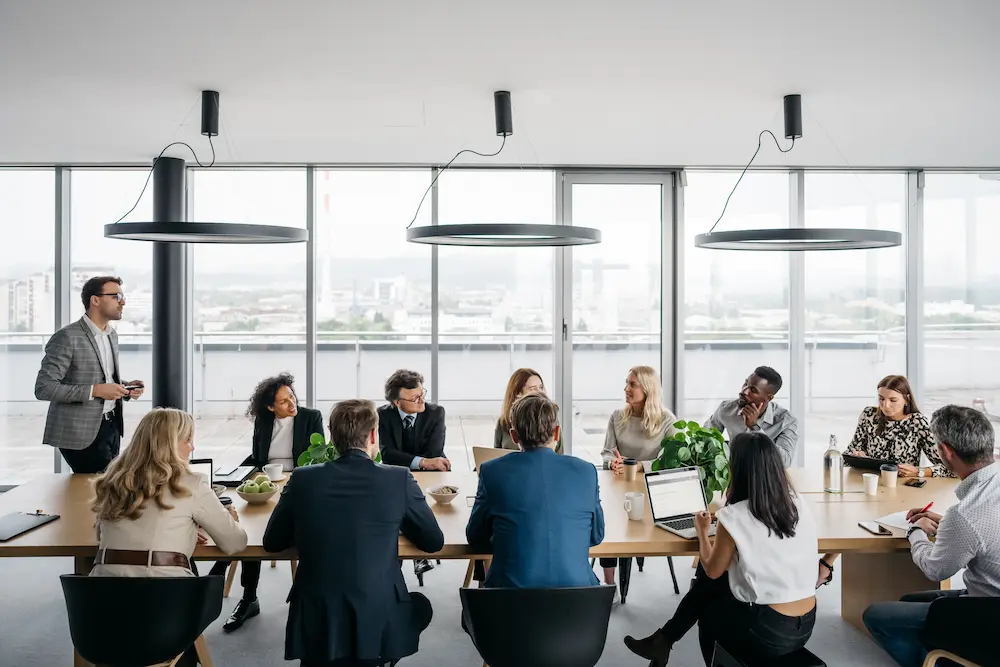 Photo of group of workers meeting in conference room.