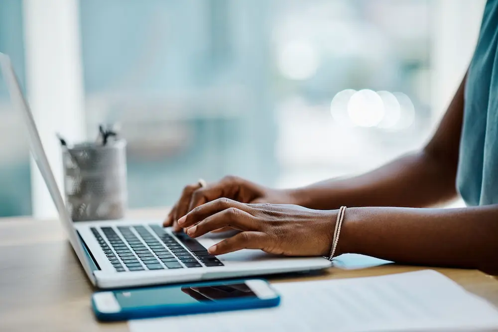 Photo of hands typing on computer keyboard.